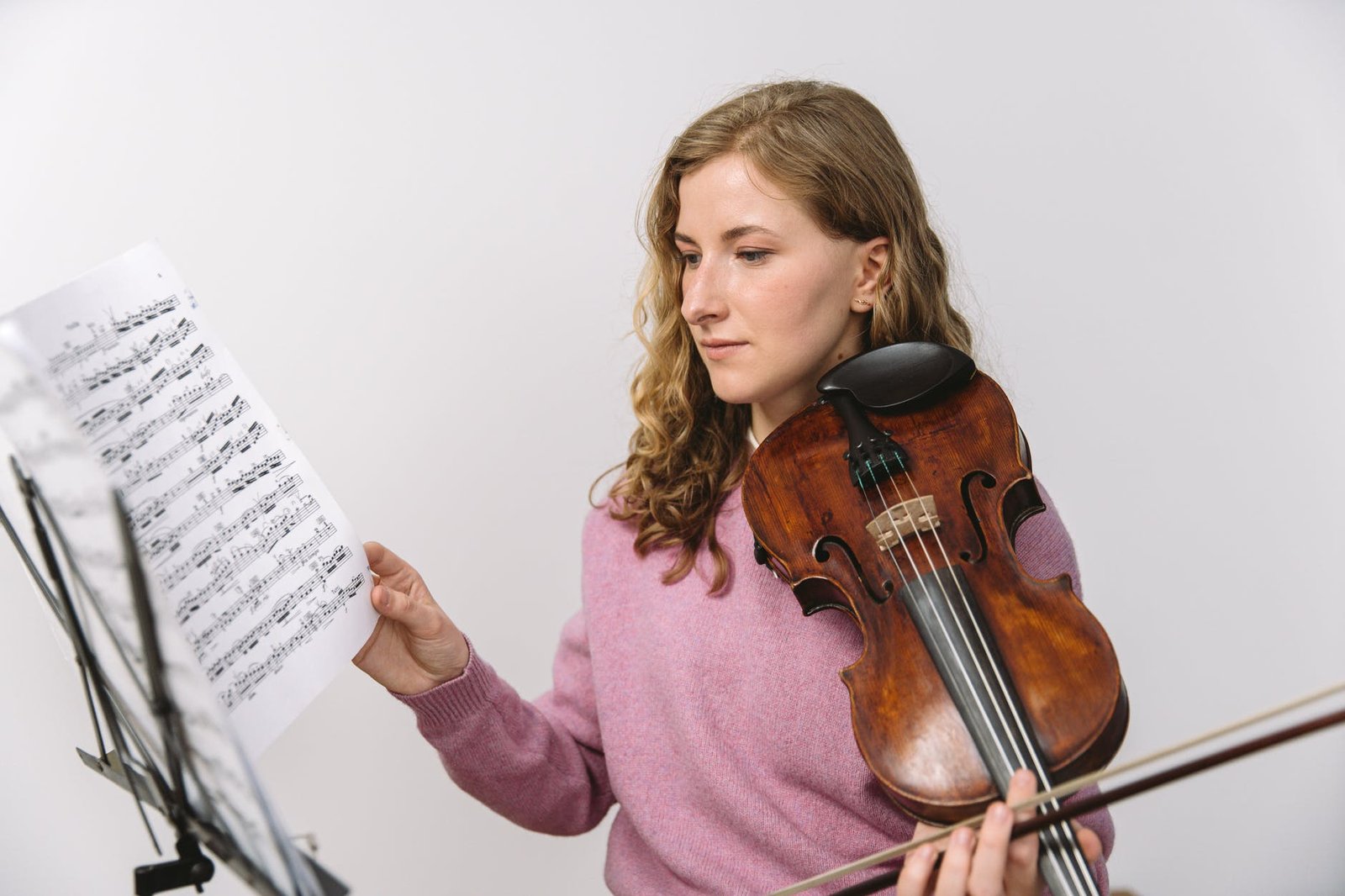 girl in pink long sleeve shirt playing violin